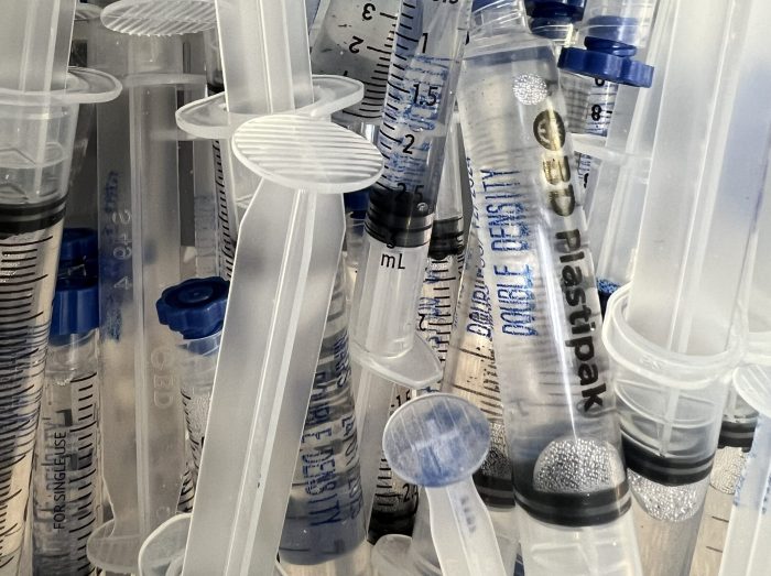 High-density psilocybe spore syringes inside a refrigerated storage box, showing clear suspension and sterile packaging.